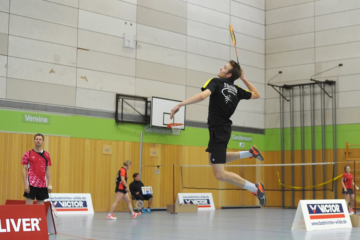 Das Bild zeigt eine Halle mit dem Fokus auf Jonas Grün, welche einen Jump Smash macht