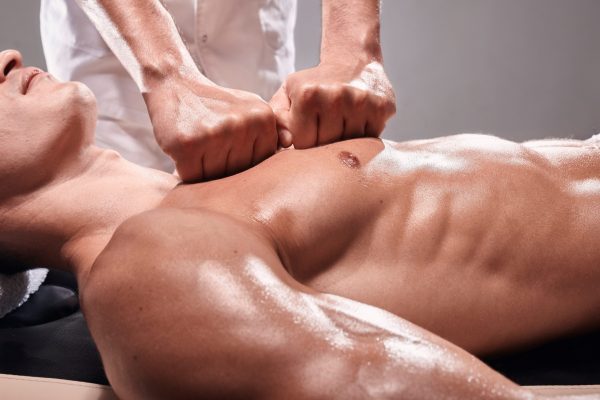 Physiotherapeut massiert einen Sportler